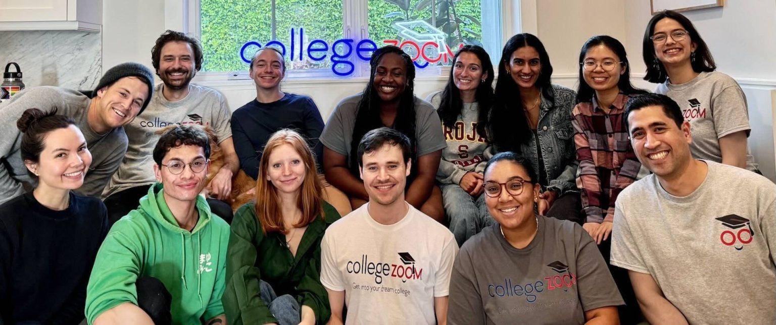 Smiling College Zoom team members in branded shirts at company retreat